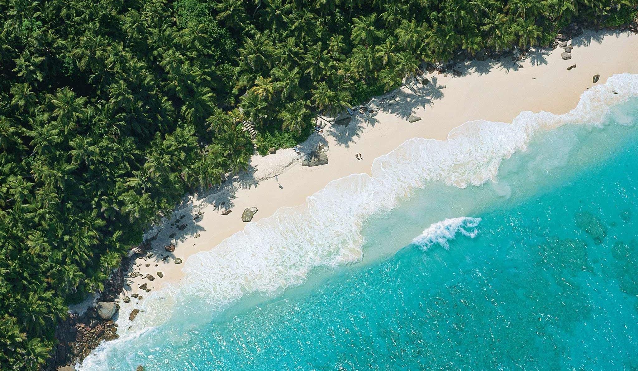 Aerial view of Seychelles showing turquoise ocean, white beaches, and lush forest